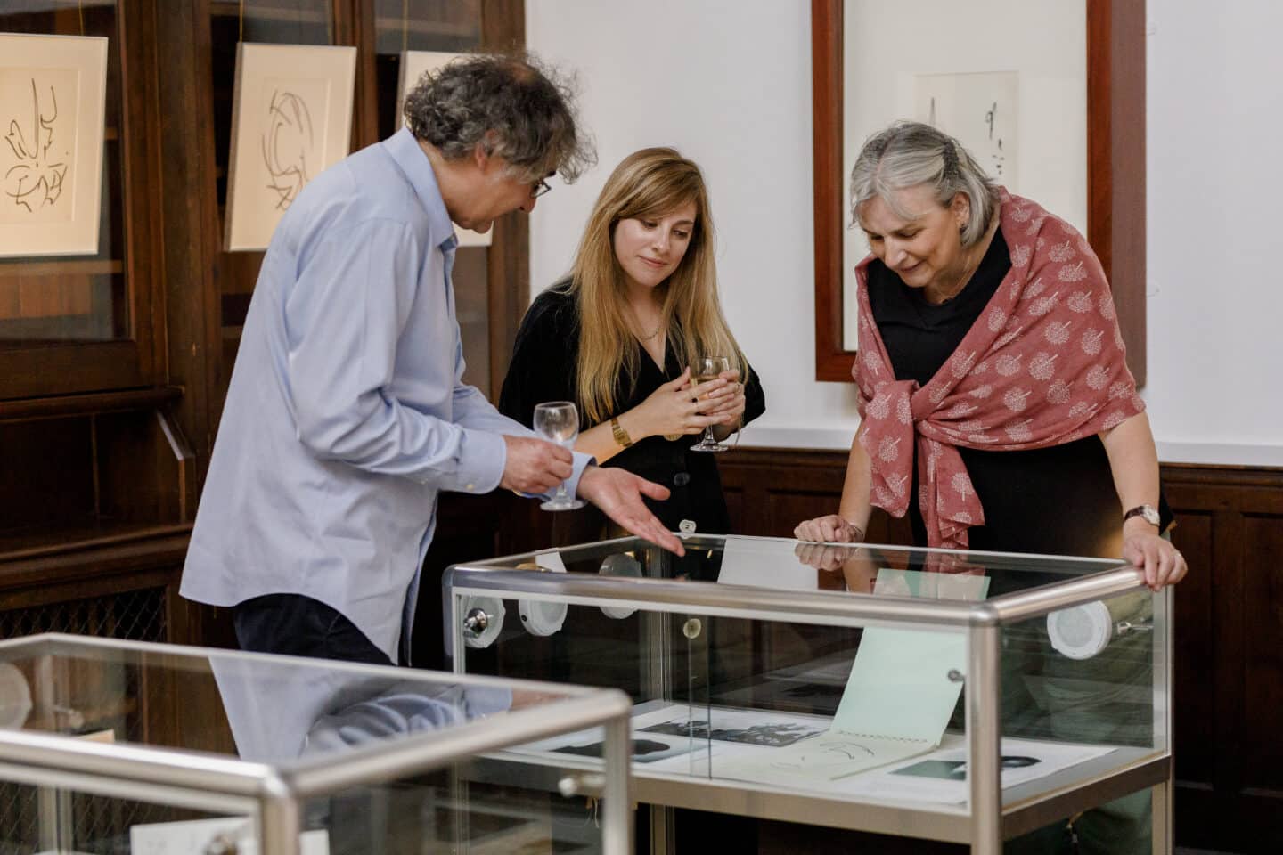 Three people examining an art exhibit.