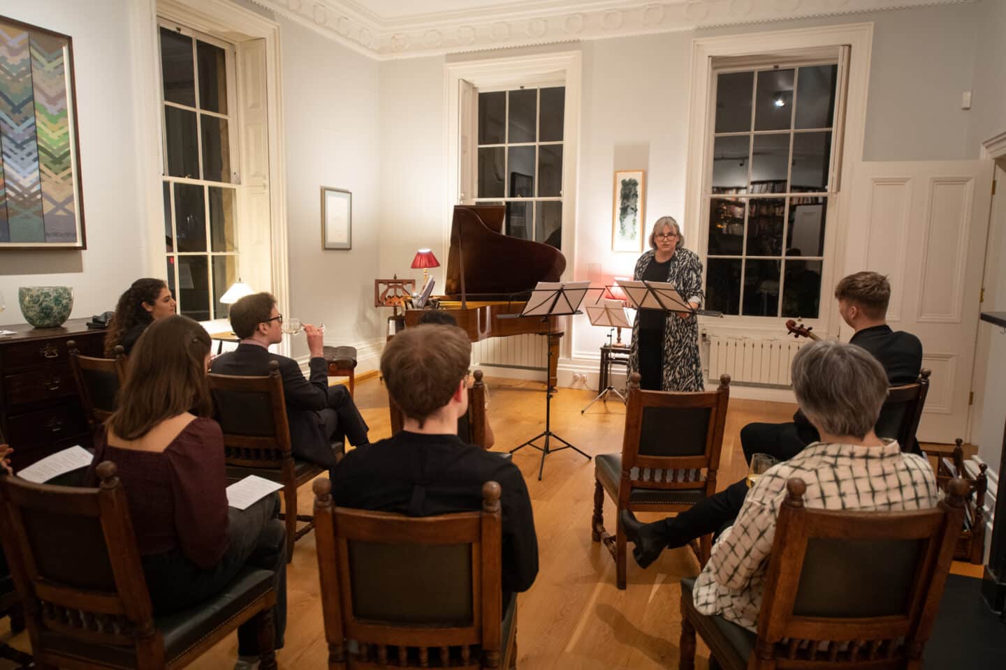 Prof Buchanan addressing a small audience at a musical recital