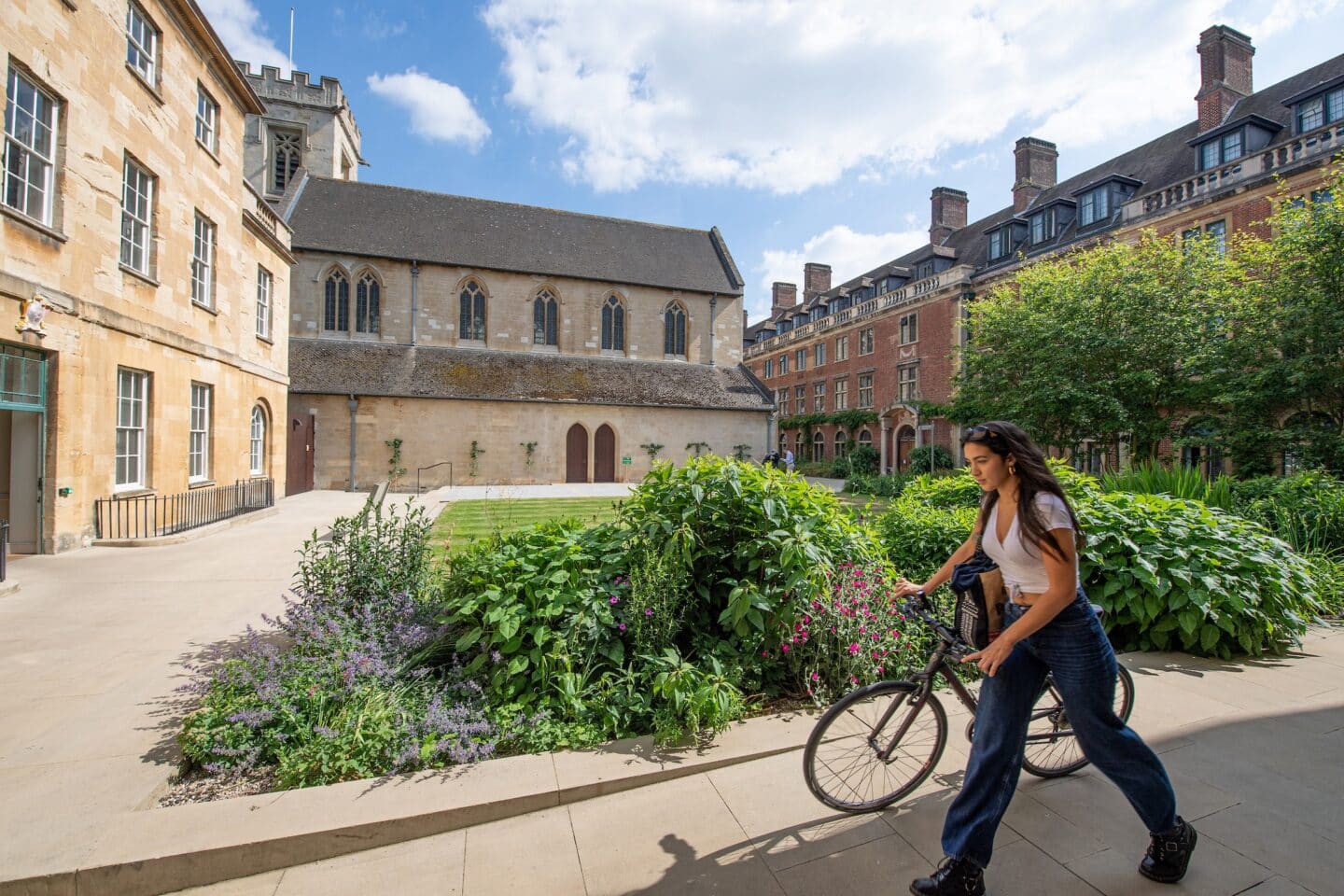 a person wheeling a bicycle through a college quad