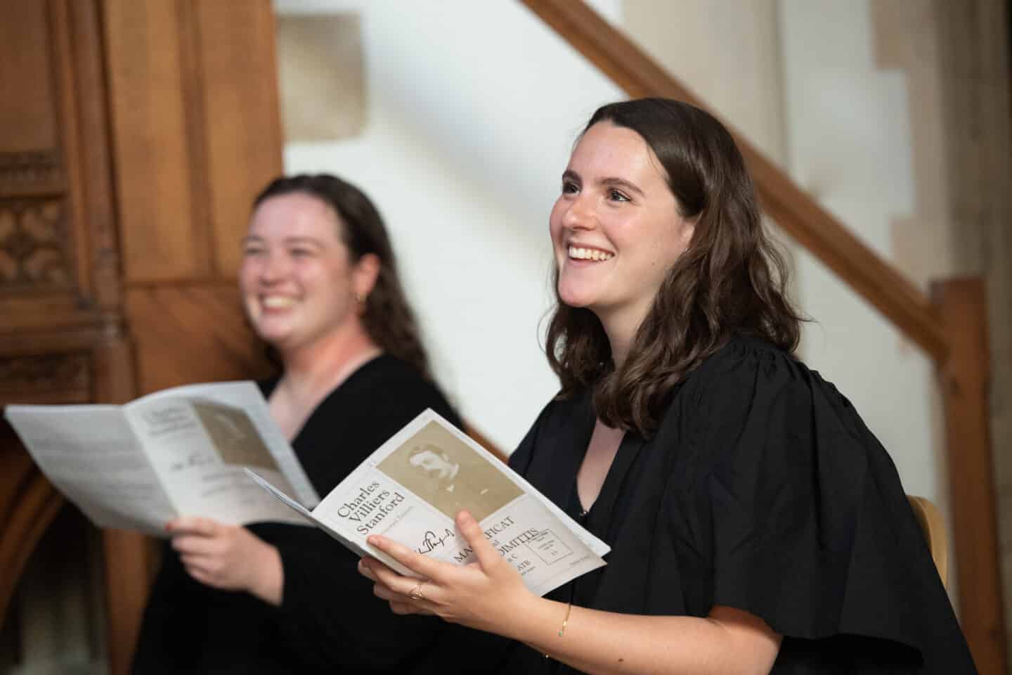 two choir singers smiling or laughing