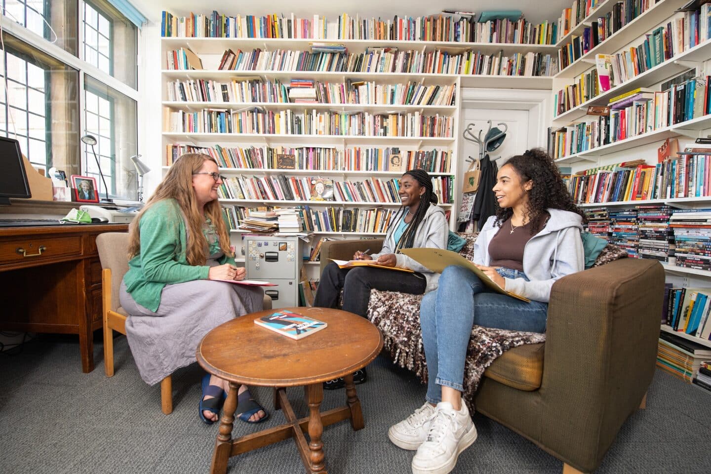 a teacher teaching two students in a large office