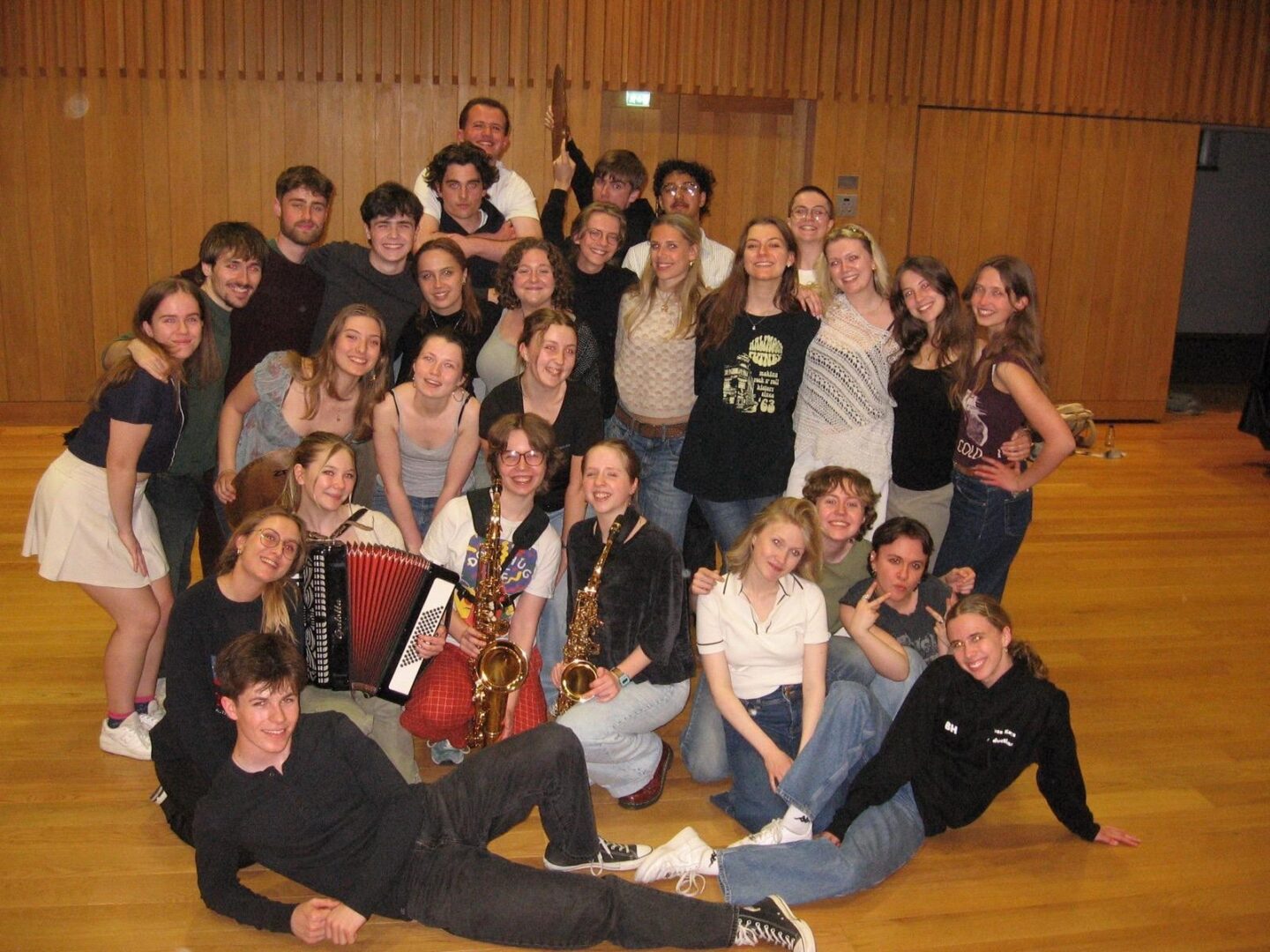 A group of young poeple crowded together and smiling