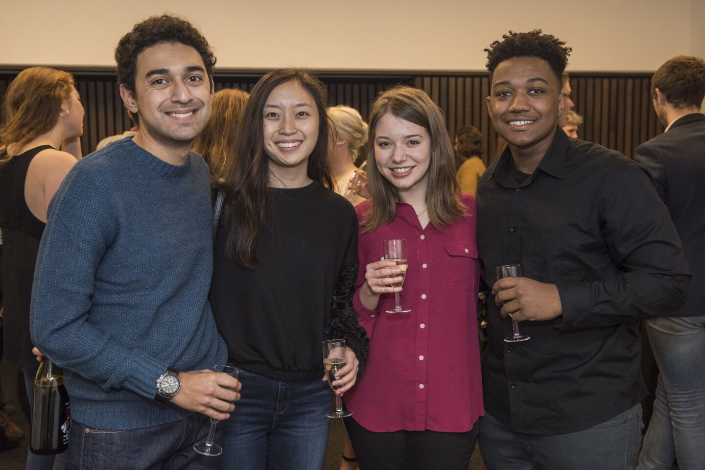 four people posing and smiling