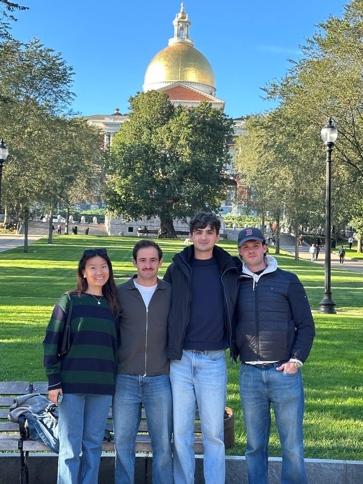Four young people standing in front of the Massachusetts State House