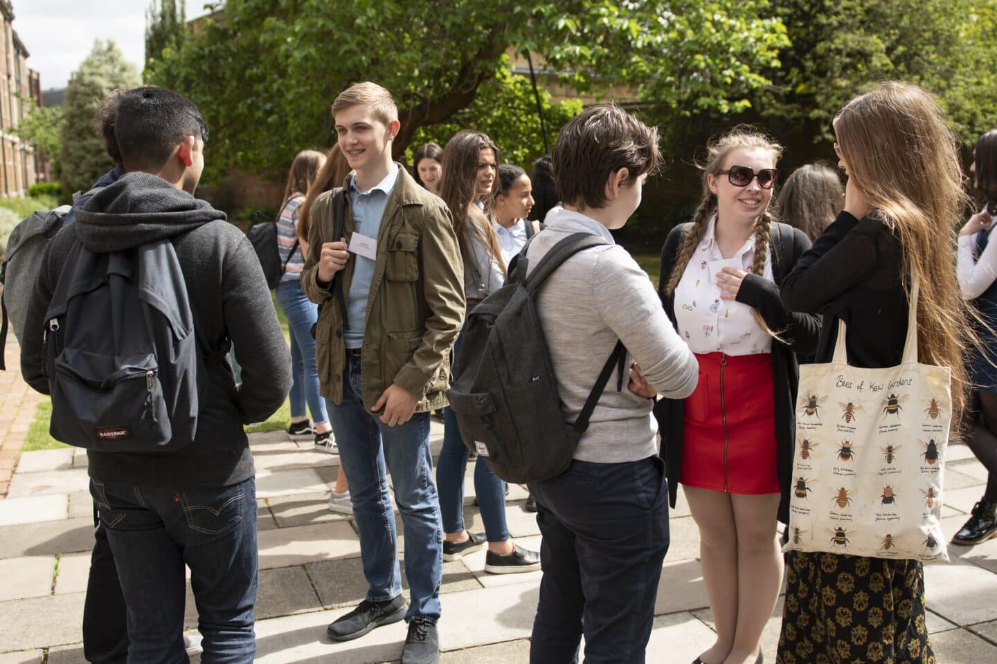 a large group of people standing outside socialising