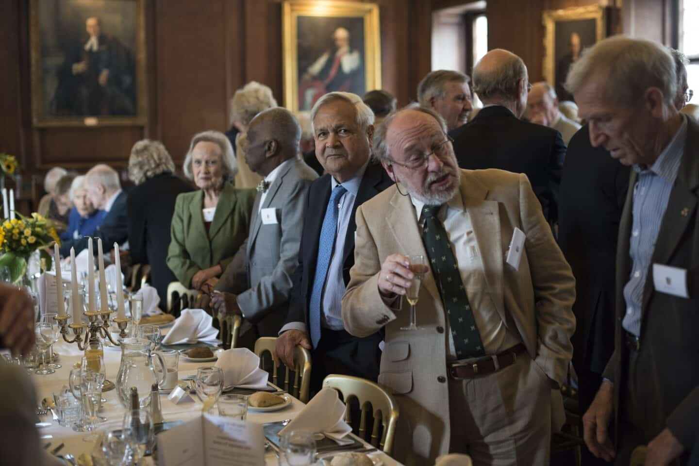 a large group of people enjoying a formal dinner inside a large hall