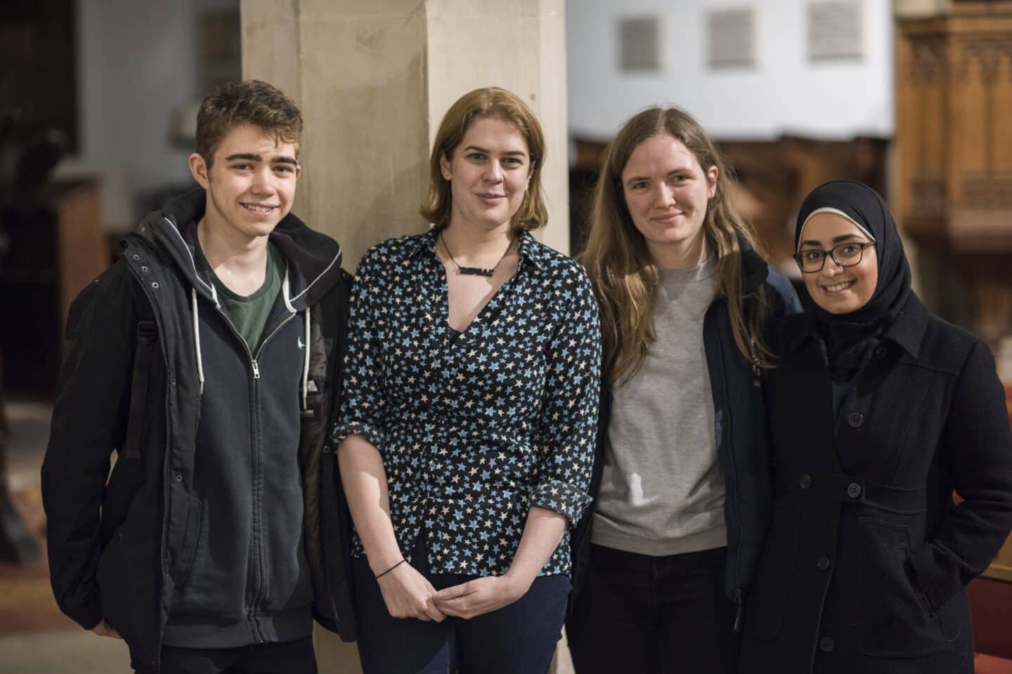 four people posing and smiling
