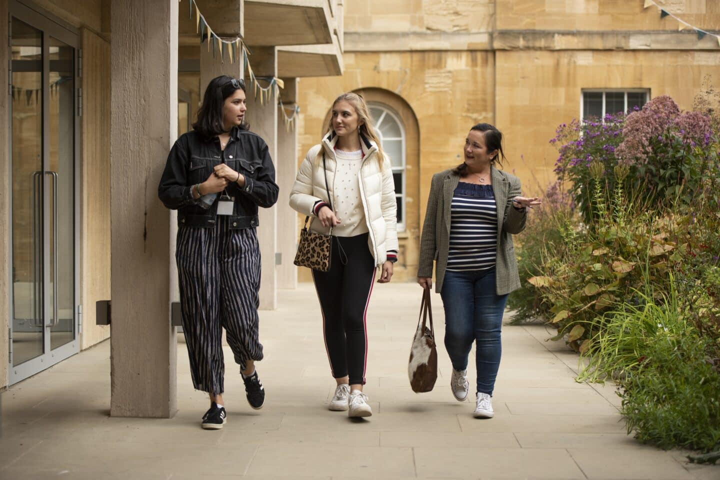 three people walking across a quad