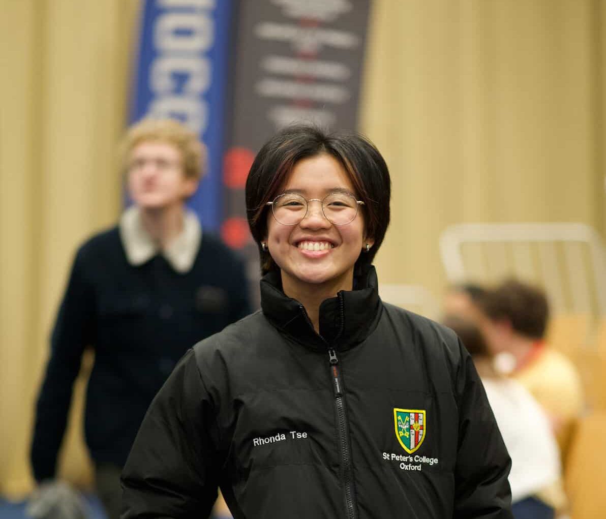 A student wearing a black puffer jacket with the St Peter's College crest