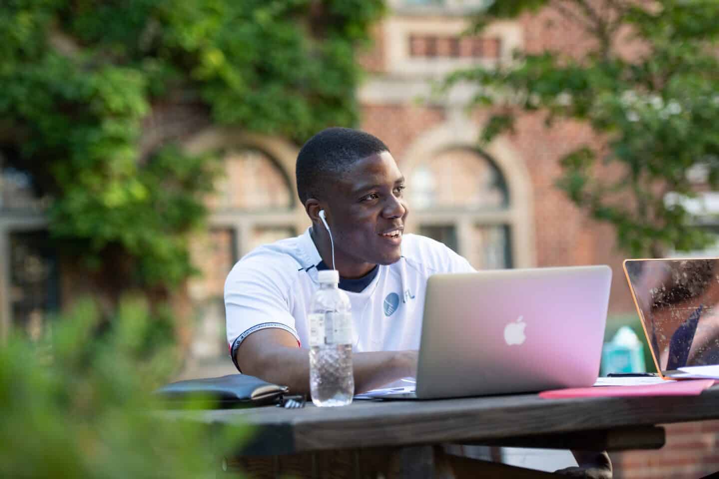 a person wearing headphones and working on a laptop outdoors