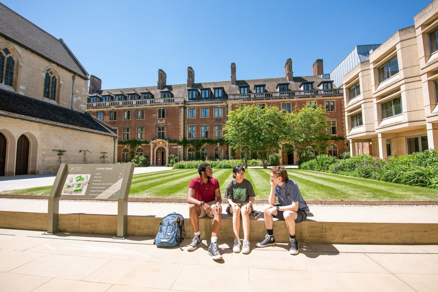 three people sitting in a college quad