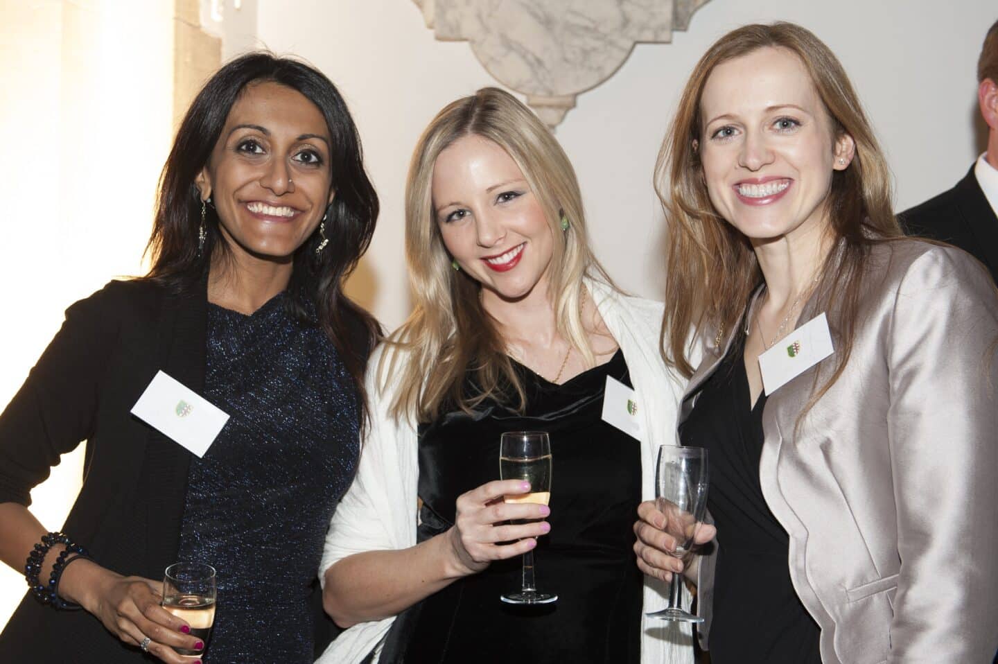 Three formally dressed women smiling