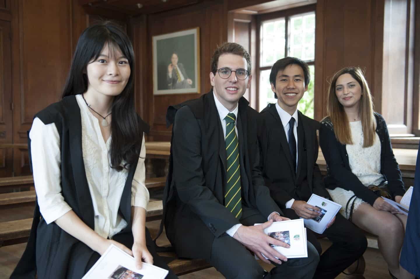 four students in formal dress posing and smiling