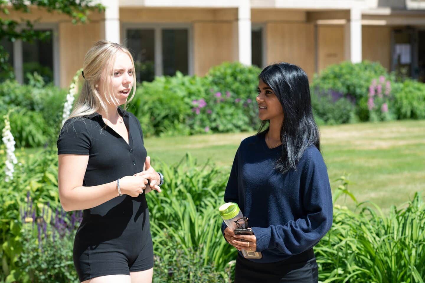 two students standing in a garden